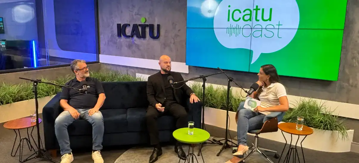 Participantes em um podcast do Icatucast, com três pessoas conversando em um estúdio moderno com tela digital ao fundo exibindo o logo do ICATU.