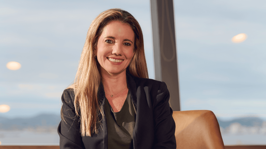 imagem de uma mulher loira com terno executivo sorrindo para a câmera
